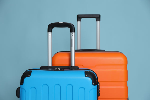Two colourful hard-shell suitcases with extended handles