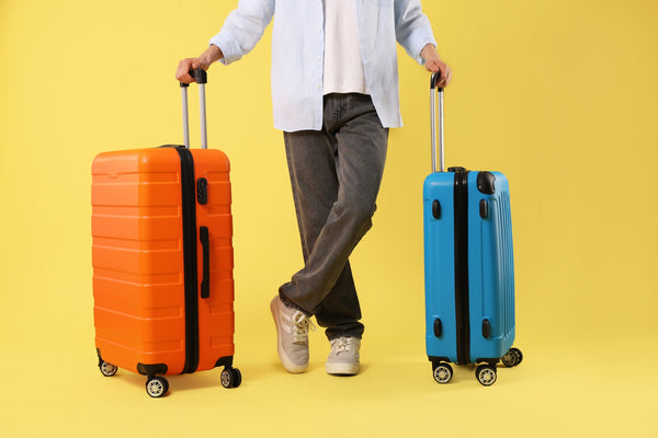 Traveller with orange and blue cabin suitcases