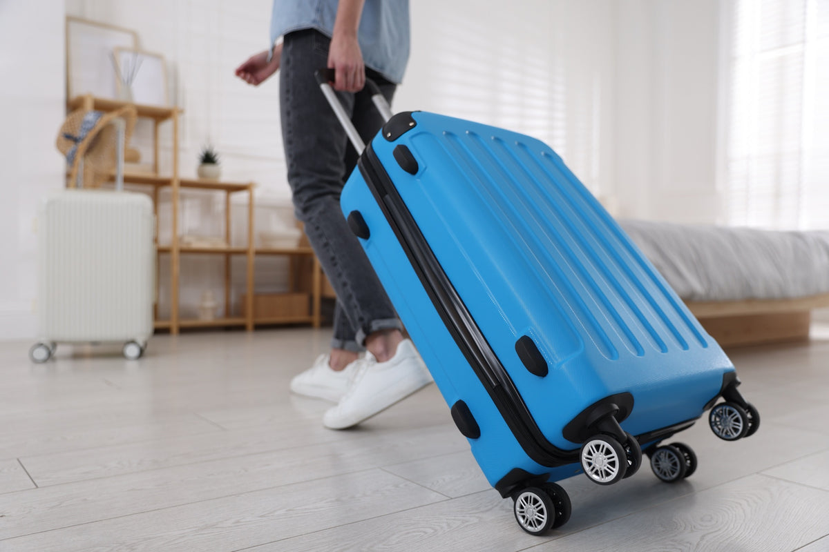 Traveller pulling a bright blue suitcase, ready for the school holidays